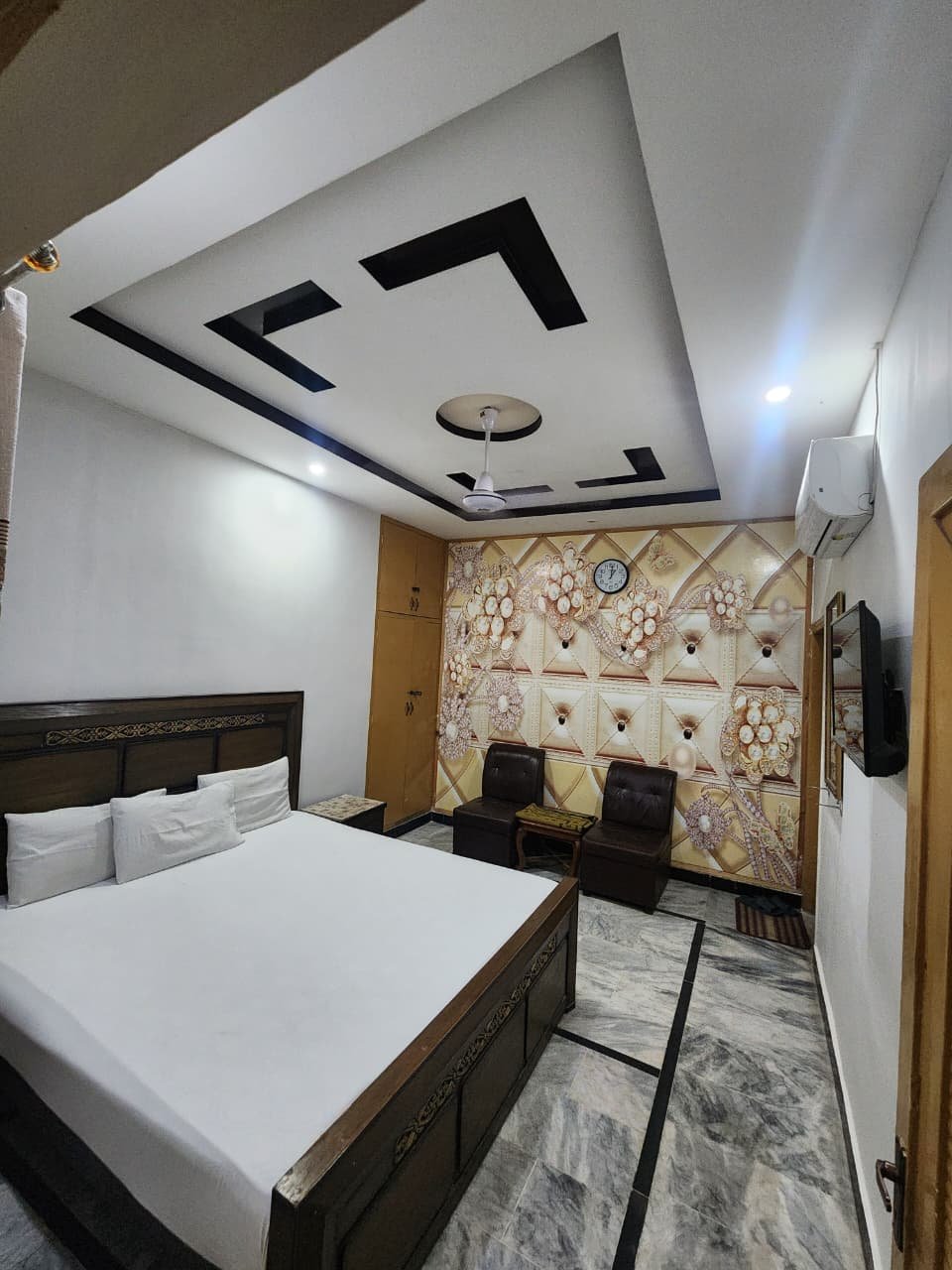 Deluxe Double Room at New Palace Guest House with a double bed, seating area and television