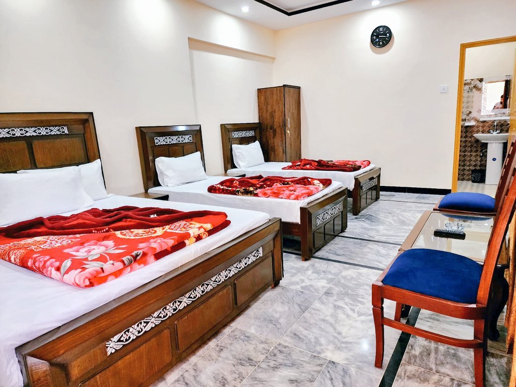 Family room made up with three beds at New Palace Guest House, G-9/4 Islamabad